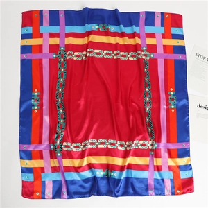 Détail à plat d'un foulard en soie carré avec centre rouge et motifs de chaînes