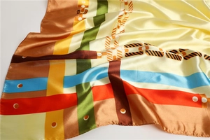 Vue détaillée d'un foulard en satin brillant avec imprimés chaînes et rayures colorées