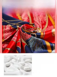 Détail du tissu satiné d'un foulard rouge et marine avec motifs de chaînes dorées