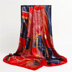 Détail d'un foulard en soie color-block avec motifs de chaînes dorées et imprimé paisley