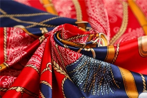Détail macro d'une écharpe en soie avec motifs de chaînes dorées et boucles luxe