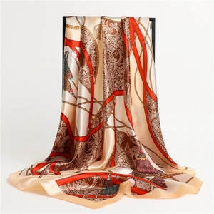 Détail du foulard en soie avec chaînes dorées et motifs paisley suspendu à la verticale