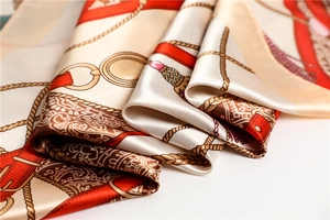 Gros plan d'un foulard en soie avec motifs de chaînes dorées et lanières en cuir