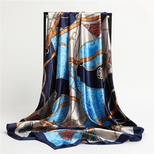 Détail d'un foulard en soie bleu marine et ciel avec motifs de chaînes dorées