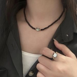 Detail von Perlenhalskette und Ringset mit schwarzen Kristallen und Katzen-Anhängern