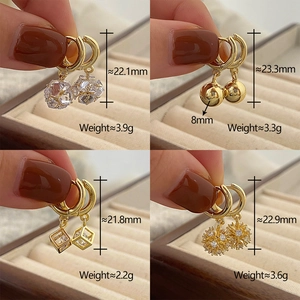 Detail view of four gold hoop earrings with crystal and geometric charms and dimensions
