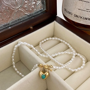 Détail du collier de perles d'eau douce avec pendentif cœur doré, turquoise et fermoir OT
