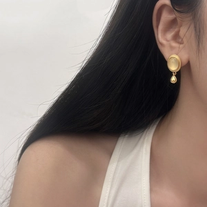 Makro-Detail des Vintage Gold-Ohrrings mit Katzenaugenstein und Tropfenanhänger