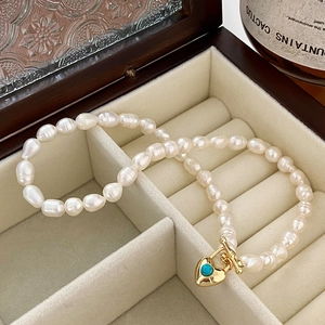Détail du collier de perles baroques avec pendentif cœur en turquoise et fermoir à bascule