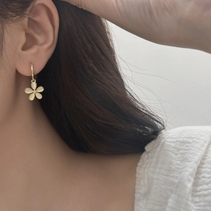 Detail of floral earring with cat-eye stone petals on model showing elegant velvet luster
