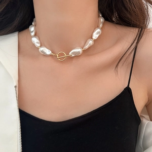 Baroque irregular pearl necklace with gold toggle clasp worn on neck for fashion