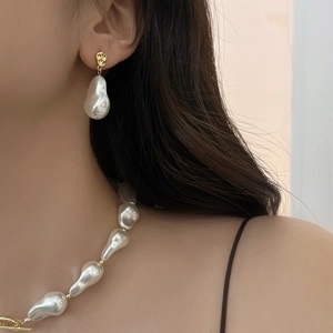Detailed view of baroque pearl necklace with gold lava texture OT buckle on neck