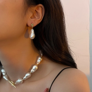 Detailed view of baroque pearl necklace set with gold OT toggle clasp on female model