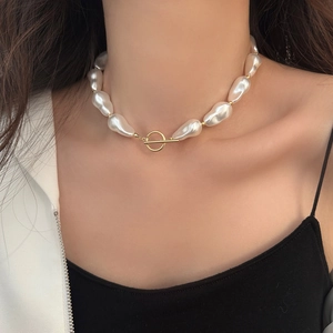 Macro detail of Baroque pearl necklace with gold OT toggle clasp and metallic beads