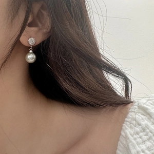 Close-up of pearl drop earrings with micro-paved cubic zirconia on a model's ear