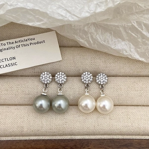 Detail of grey and white round pearl drop earrings with micro-paved zircon settings