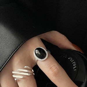 Detail of minimalist S925 silver ring with black onyx stone on dark leather