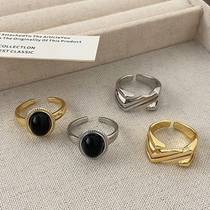 Detail view of retro black gem rings and geometric cutout rings in gold and silver finish