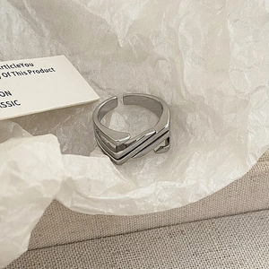 Macro shot of layered silver geometric ring with an adjustable open design in minimalist style