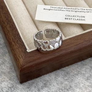 Detail shot of silver double-row heart ring with zircon inlay on a velvet tray