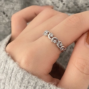 Bague étoile et lune en argent avec zircons, portée avec un vêtement en maille