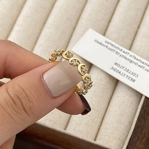 Détail d'une bague croissant de lune dorée avec zircons sur fond de boîte à bijoux
