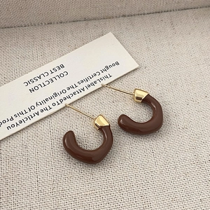 Dettaglio orecchini a cerchio a C smaltati marroni con bordi dorati e stile vintage