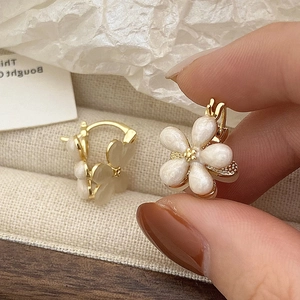 Elegant floral hoop earrings featuring pearlescent petals and golden beads detail