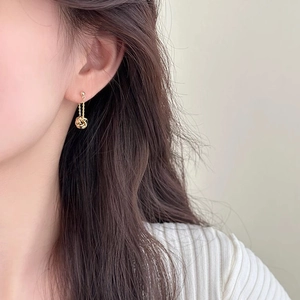 Detail of elegant gold tassel drop earrings with delicate chains and spherical pendants