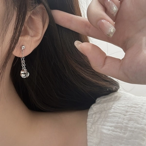Detailed close-up of a silver tassel drop earring with geometric twist pendant on model