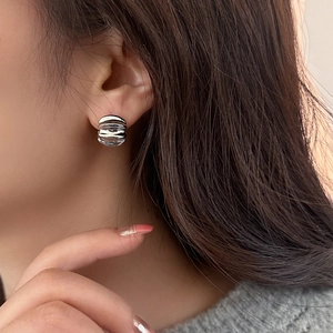 Silver textured layered circle earrings with metallic polished finish on female model