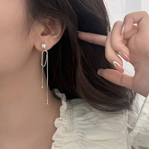 Elegant silver tassel earrings with pearls and long metal chains on model