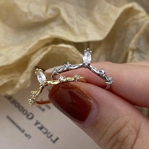 Detailed view of silver and gold crown rings with marquise cut zircon stones