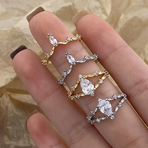 Macro view of stacked gold and silver crown rings with teardrop cubic zirconia