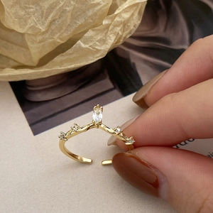 Detail of gold crown ring with marquise zircon and side diamonds on vintage background