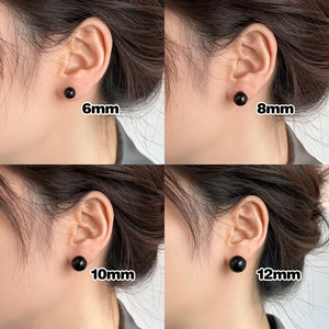 Size comparison of four black round stud earrings from 6mm to 12mm on a model