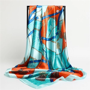 Détail macro d'un foulard en soie avec motifs de chaînes équestres en bleu, orange et sarcelle