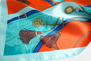 Gros plan d'un foulard en soie aux motifs de cordes nautiques orange et bleu avec drapé