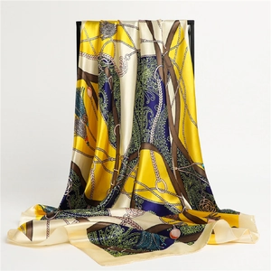 Détail d'un foulard en soie montrant des motifs de brides et chaînes dorées élégants