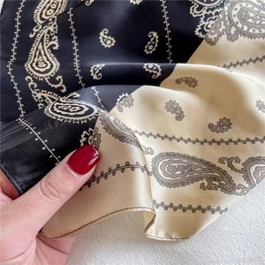 Detail eines Seidenschals mit Paisley-Muster-Kontrast und feinen Nähten an der Kante