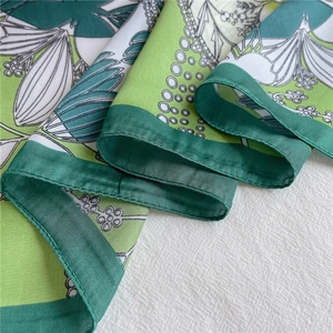 Detailed macro view of the premium floral silk scarf with hand-rolled edges and botanical print