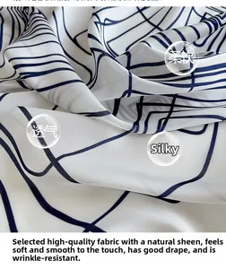 Detailed view of white silk scarf showing blue geometric lines and soft, breathable texture