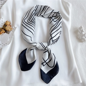 Detail of silk scarf with black and white geometric lines draped on white clothing