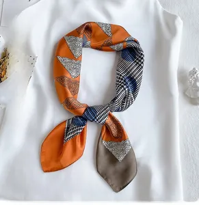 Detailed pattern of paisley and houndstooth on a 70x70cm silk-like orange square scarf