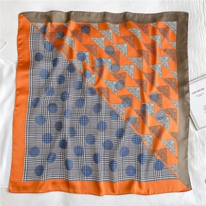 Detail of square silk scarf with paisley pattern, houndstooth and blue polka dots