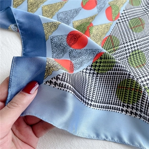 Detail of silk-like scarf showing paisley patterns, polka dots, and houndstooth texture