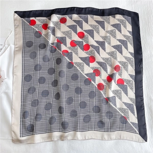 Detail of multi-pattern silk scarf featuring houndstooth, polka dots and paisley prints