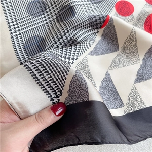 Detail of silk satin scarf featuring mixed paisley, houndstooth, and polka dot patterns