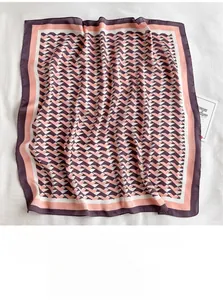 Close-up of elegant V-shaped geometric print on silky satin neck scarf with contrast borders