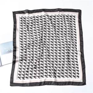 Detail of geometric pattern on silk scarf with black and beige zigzag color blocking